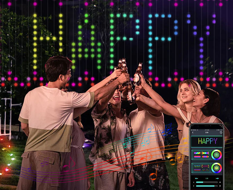 Photo d'une fête dans un jardin la nuit : le rideau LED affiche le message « HAPPY » en pixels multicolores